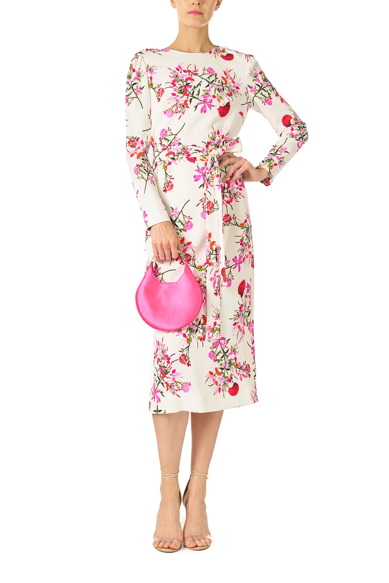 Monique Lhuillier jewel neckline dress with long sleeves and detachable, self-tie belt in silk white fuchsia floral print - front with demi handbag.