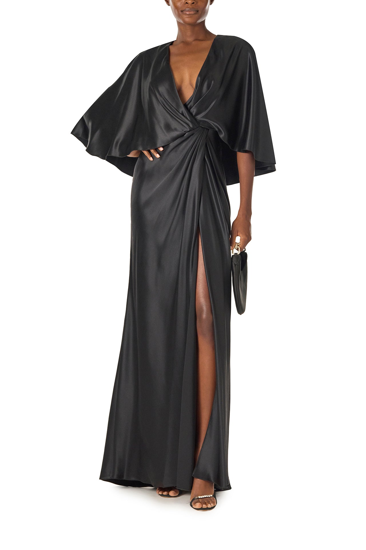Monique Lhuillier deep V-Neck draped gown with attached capelet and high leg slit in black crepe back satin - front with Demi handbag.