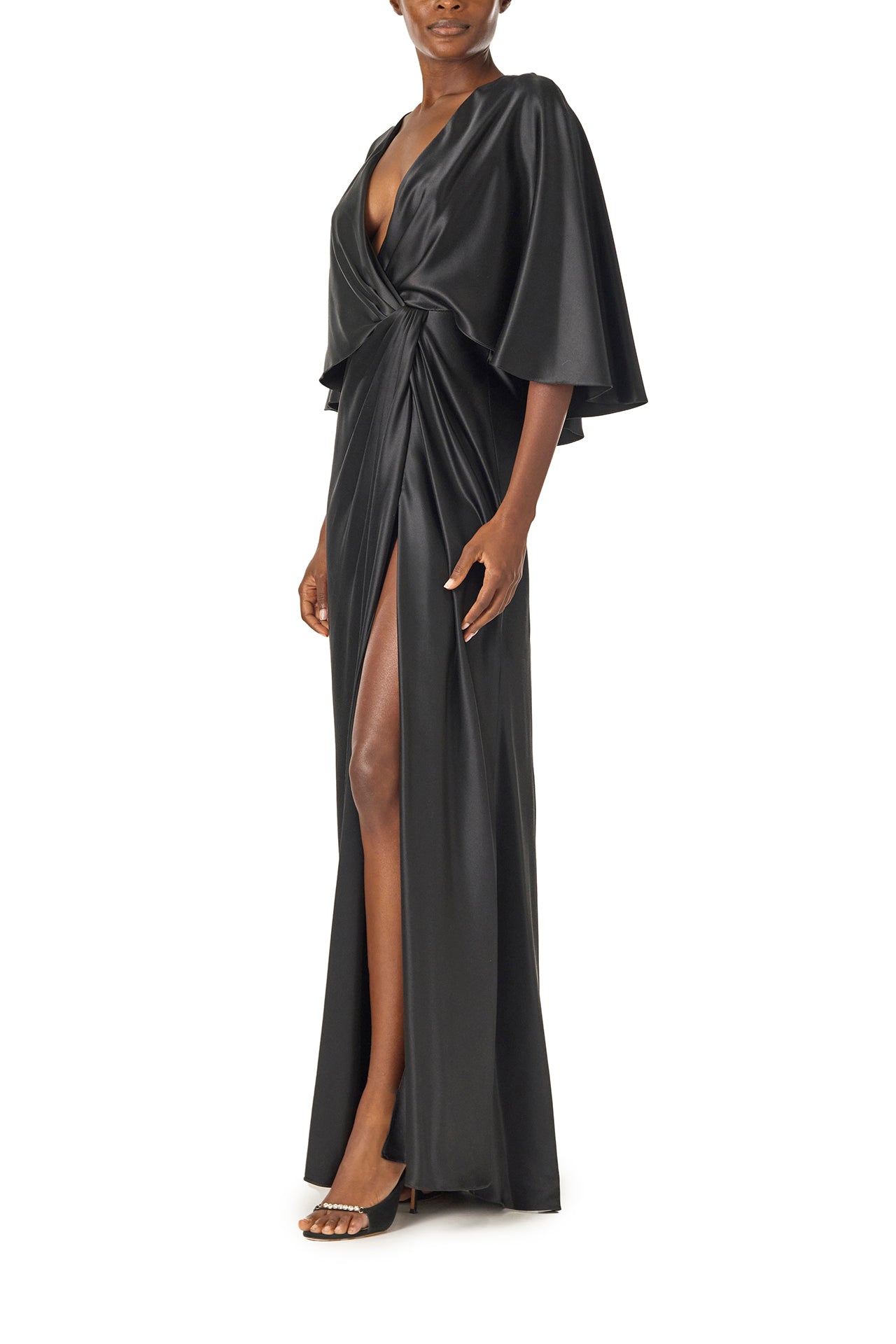 Monique Lhuillier deep V-Neck draped gown with attached capelet and high leg slit in black crepe back satin - side.