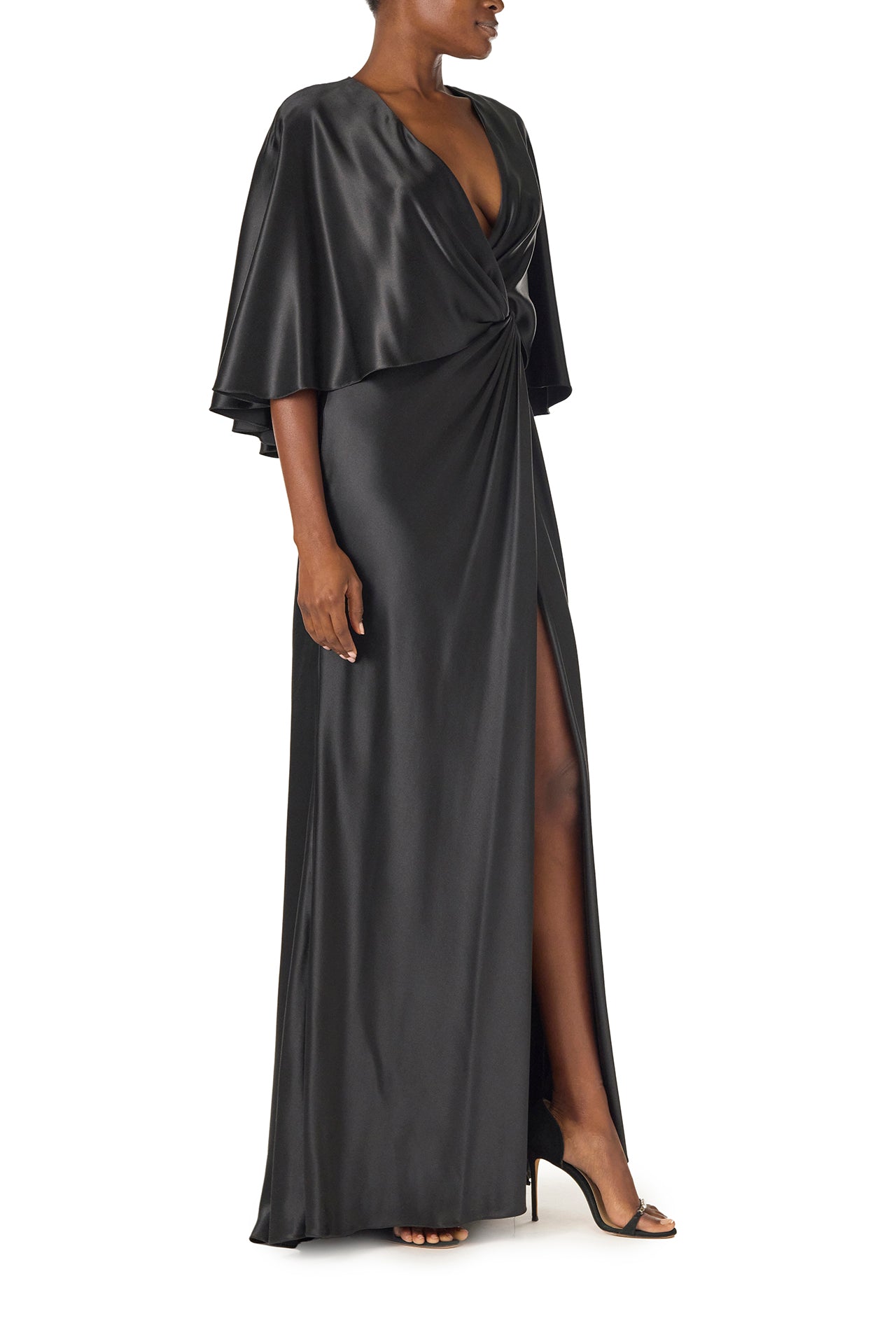 Monique Lhuillier deep V-Neck draped gown with attached capelet and high leg slit in black crepe back satin - right side.