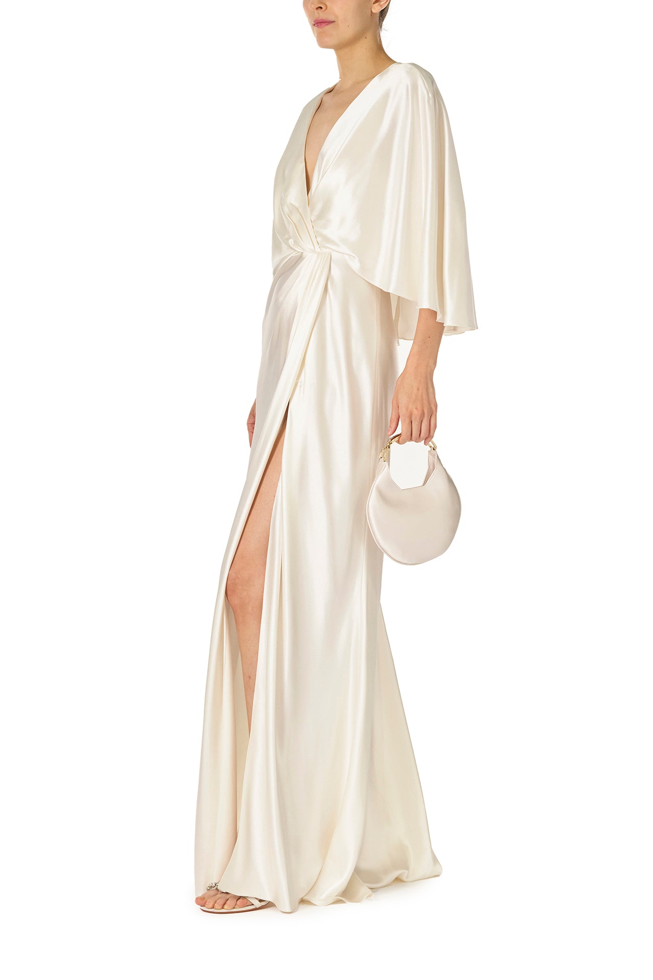 Monique Lhuillier deep V-Neck draped gown with attached capelet and high leg slit in silk white crepe back satin - side with Demi handbag.