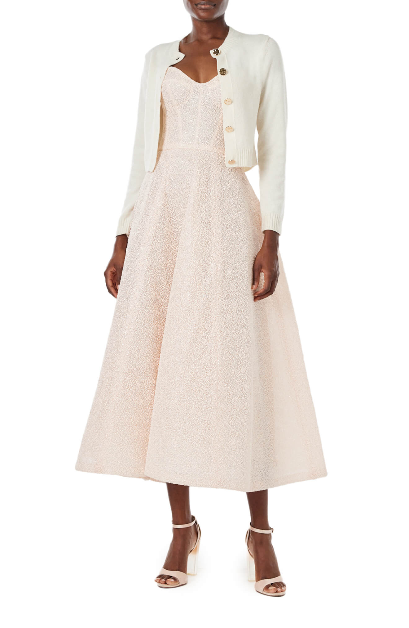 Monique Lhuillier Spring 2024 white knit cropped cardigan over blush embroidered dress.