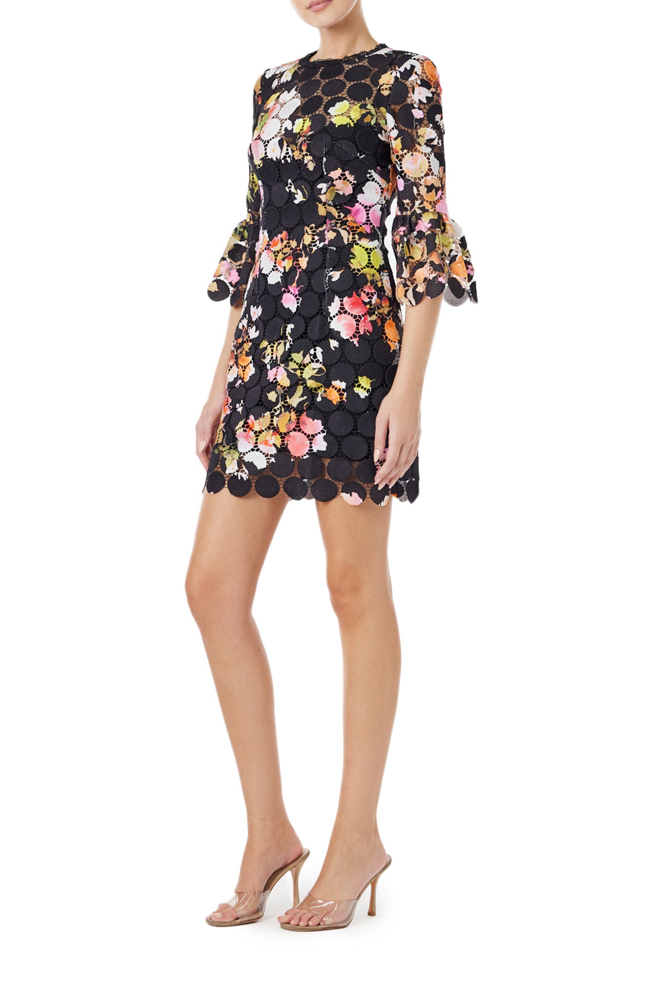 Monique Lhuillier Spring 2024 jewel neck mini dress in black/floral printed circle lace with bracelet length bell sleeves - left side.