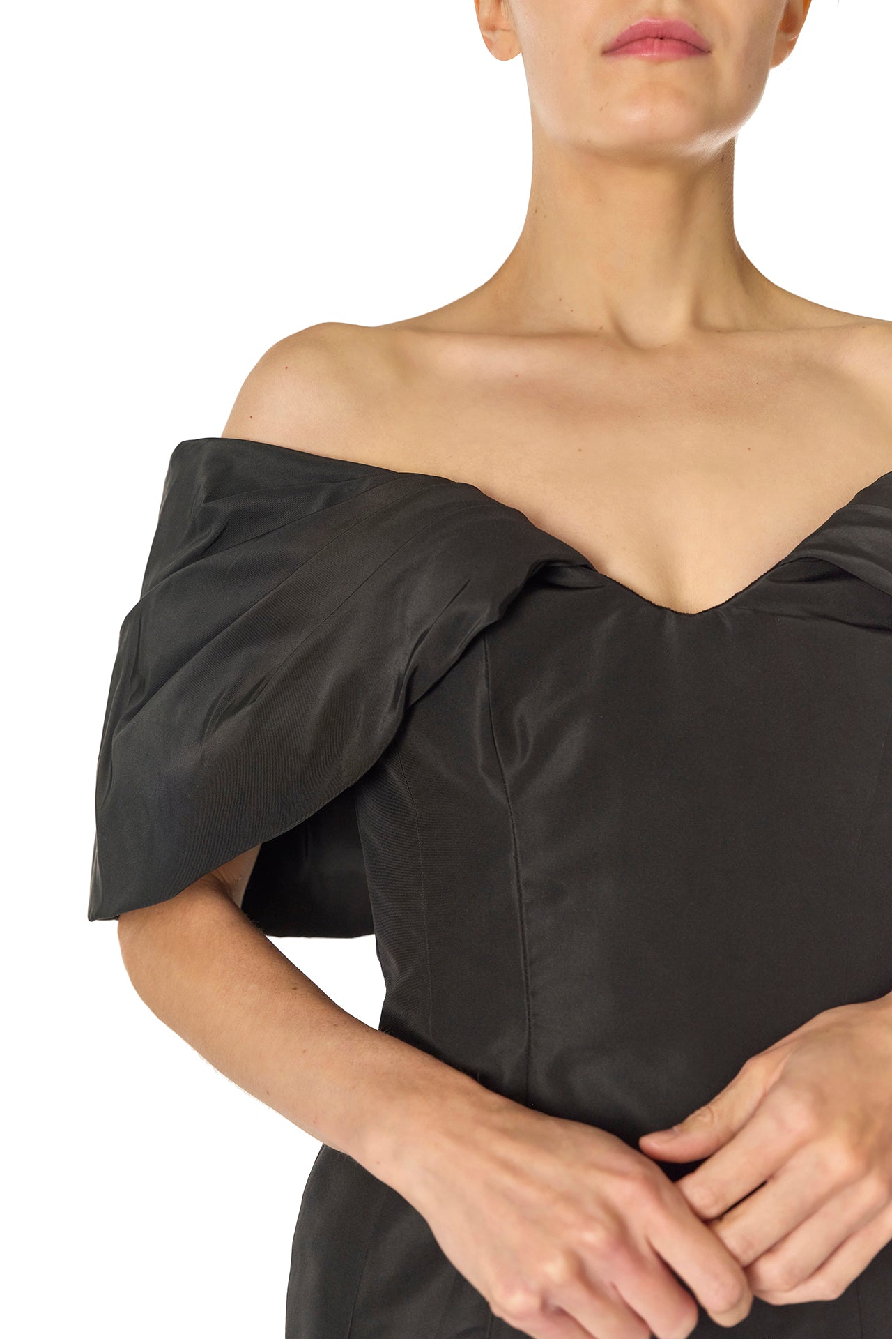 Monique Lhuillier Fall 2024 Off-the-shoulder tea length column dress with draped neckline and train in noir silk faille - neckline.