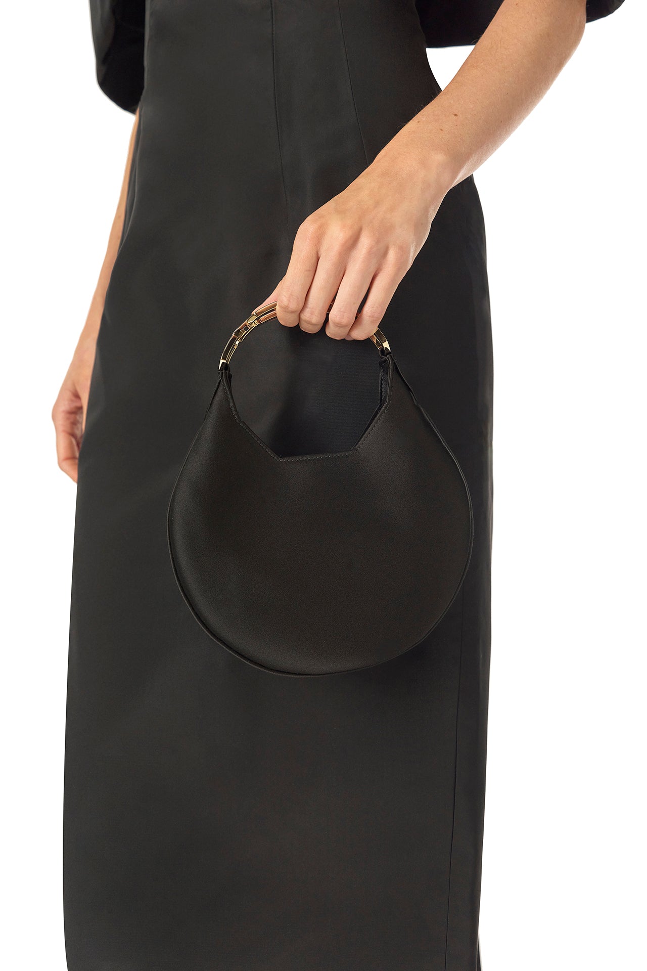 Monique Lhuillier Fall 2024 Off-the-shoulder tea length column dress with draped neckline and train in noir silk faille - with Demi bag in noir.