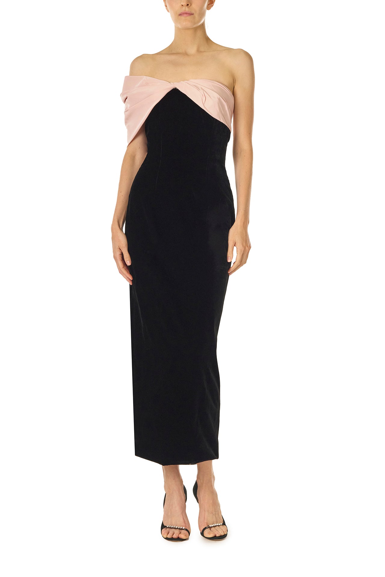 Monique Lhuillier Fall 2024 black velvet off the shoulder sheath dress with pale blush draped, asymmetric twist detail at neckline - front.
