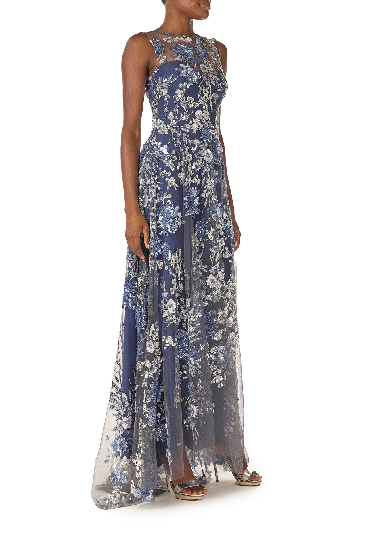 Monique Lhuillier sleeveless, sequin tulle gown with illusion neckline and slight high-low hem in navy multi colors - side.