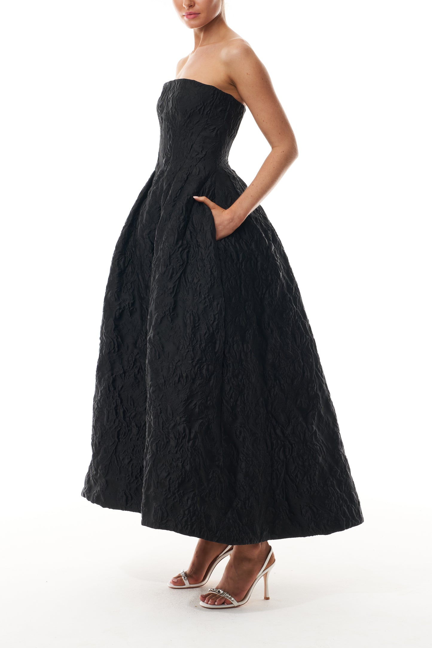 Monique Lhuillier Fall 2025 strapless midi-length dress with pockets in noir floral jacquard - side.