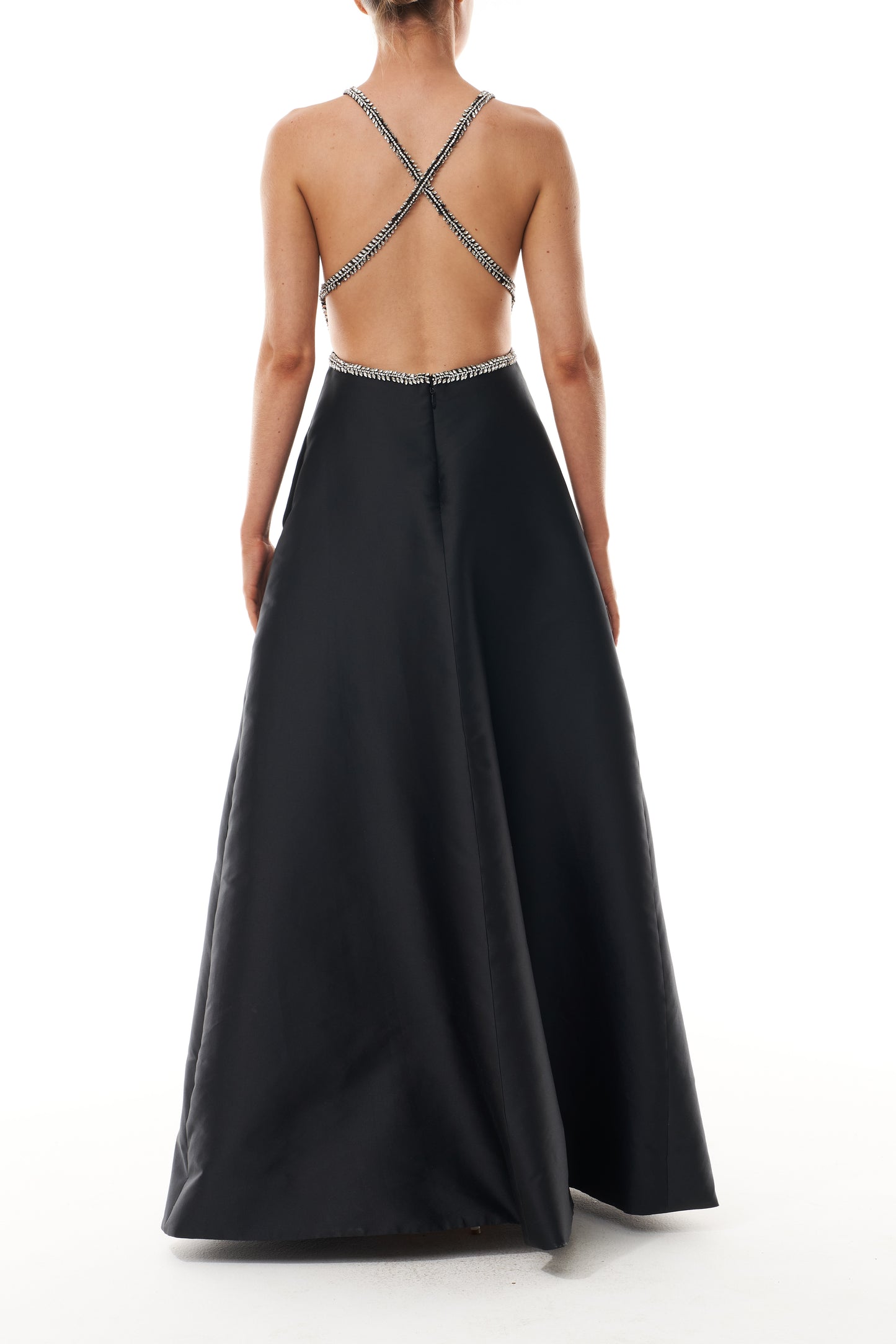 Monique Lhuillier Fall 2025 floor length ball gown with cut-out details and crystal embroidered piping in noir mikado - back.