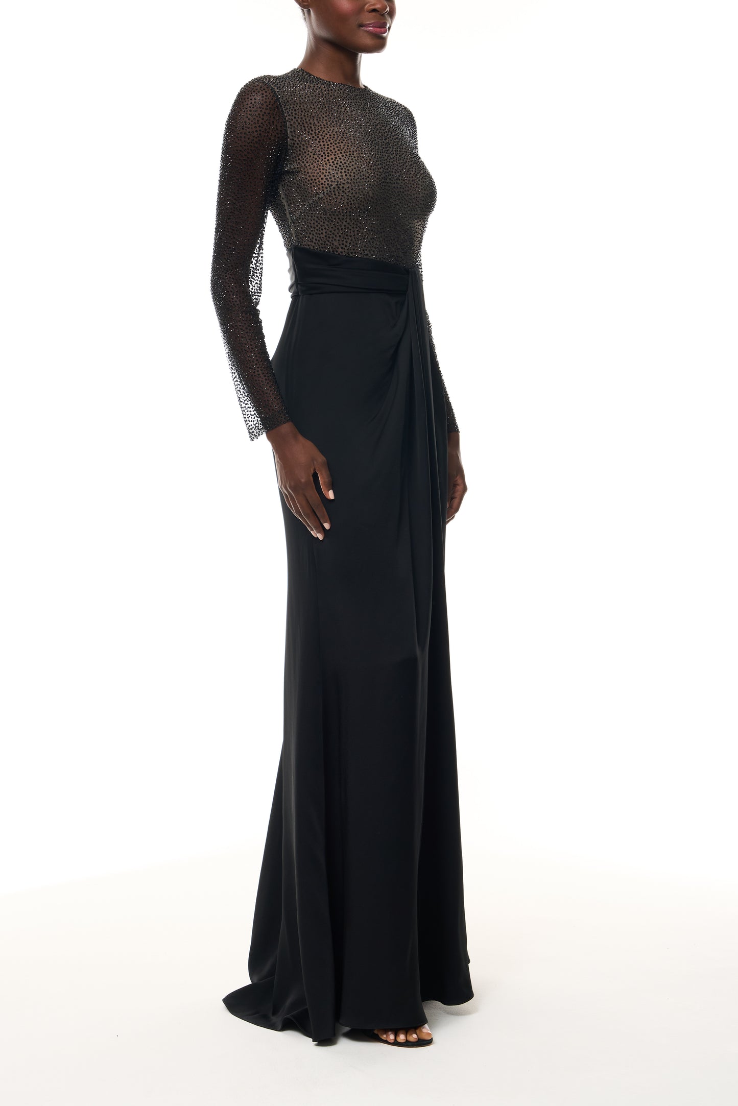 Monique Lhuillier Fall 2025 RTW Noir Long Sleeve Hotfix gown with embellished bodice and front slit - side.
