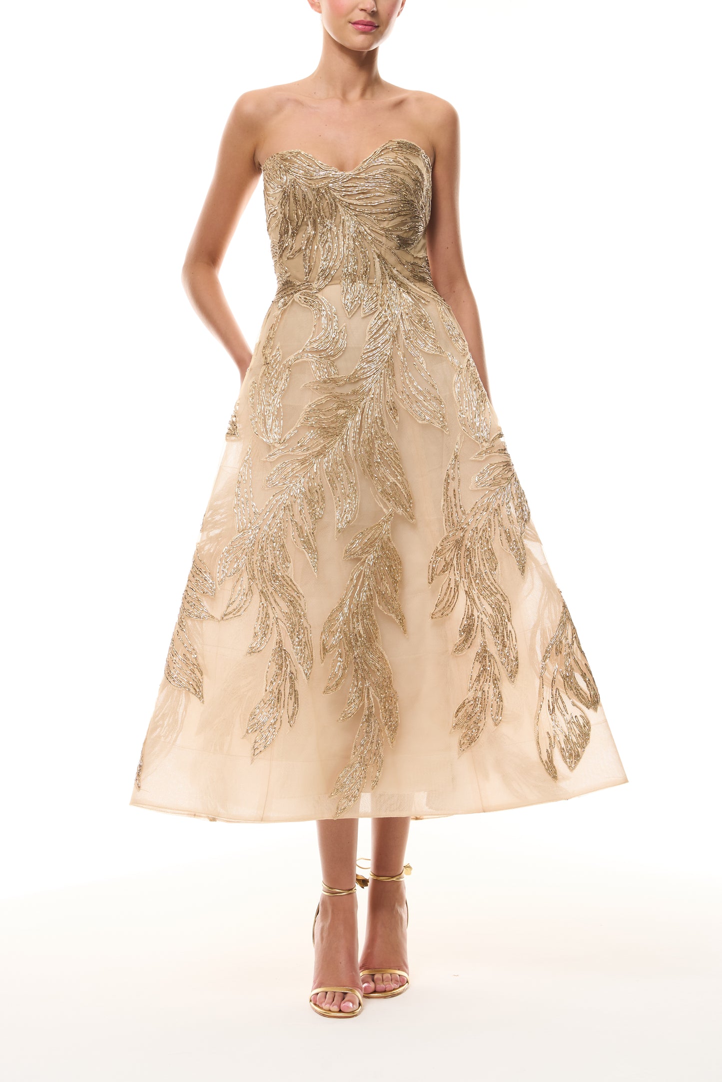 Monique Lhuillier Fall 2025 strapless dress with tea-length skirt and sweetheart neckline in gold feather embroidery - front.