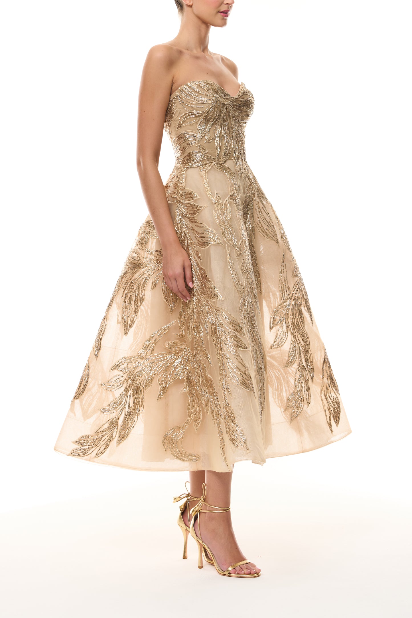 Monique Lhuillier Fall 2025 strapless dress with tea-length skirt and sweetheart neckline in gold feather embroidery - side.