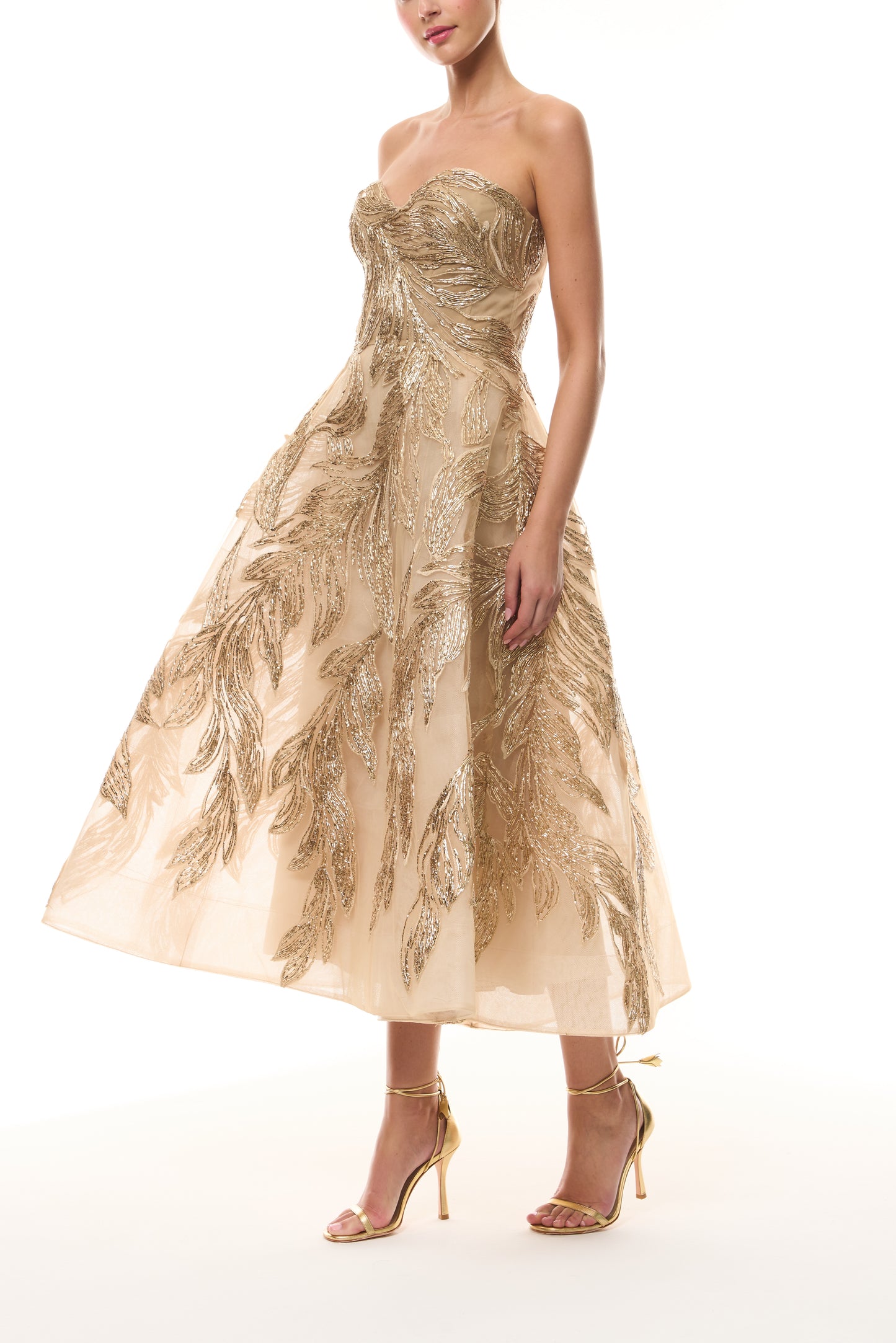 Monique Lhuillier Fall 2025 strapless dress with tea-length skirt and sweetheart neckline in gold feather embroidery - side.