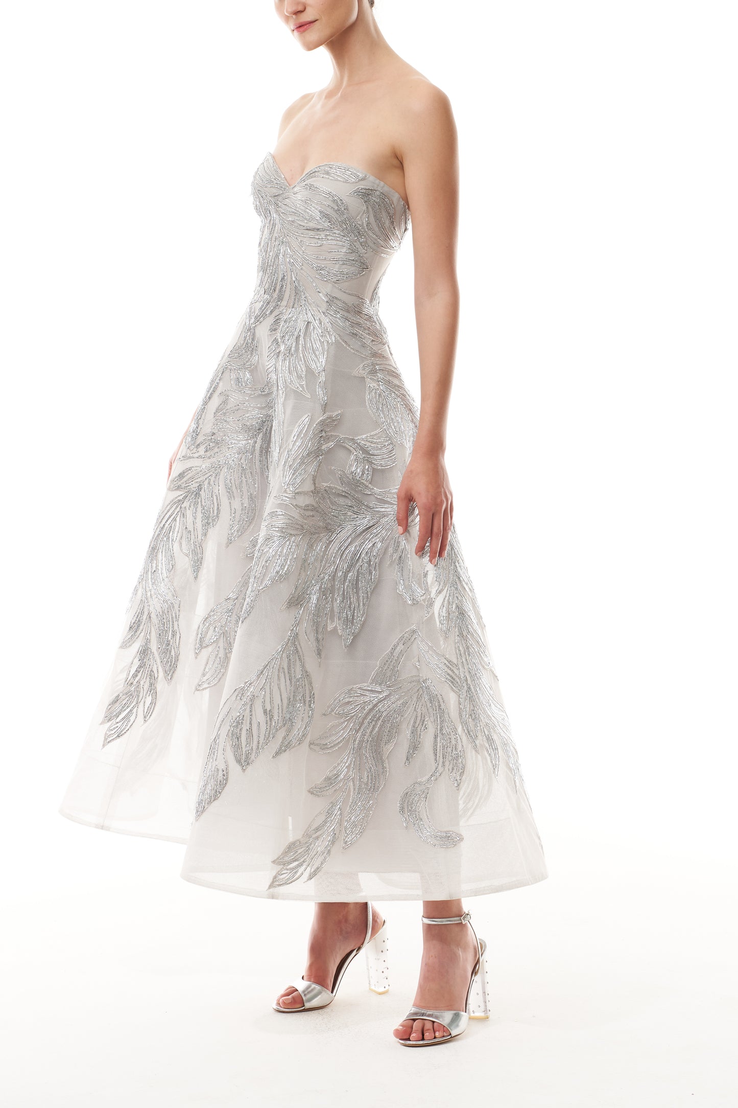 Monique Lhuillier Fall 2025 strapless dress with tea-length skirt and sweetheart neckline in silver feather embroidery - side.