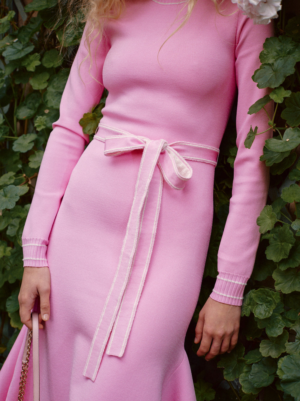 Monique Lhuillier Fall 2024 pink knit long sleeve dress with handkerchief hem and self-tie belt - look book detail.