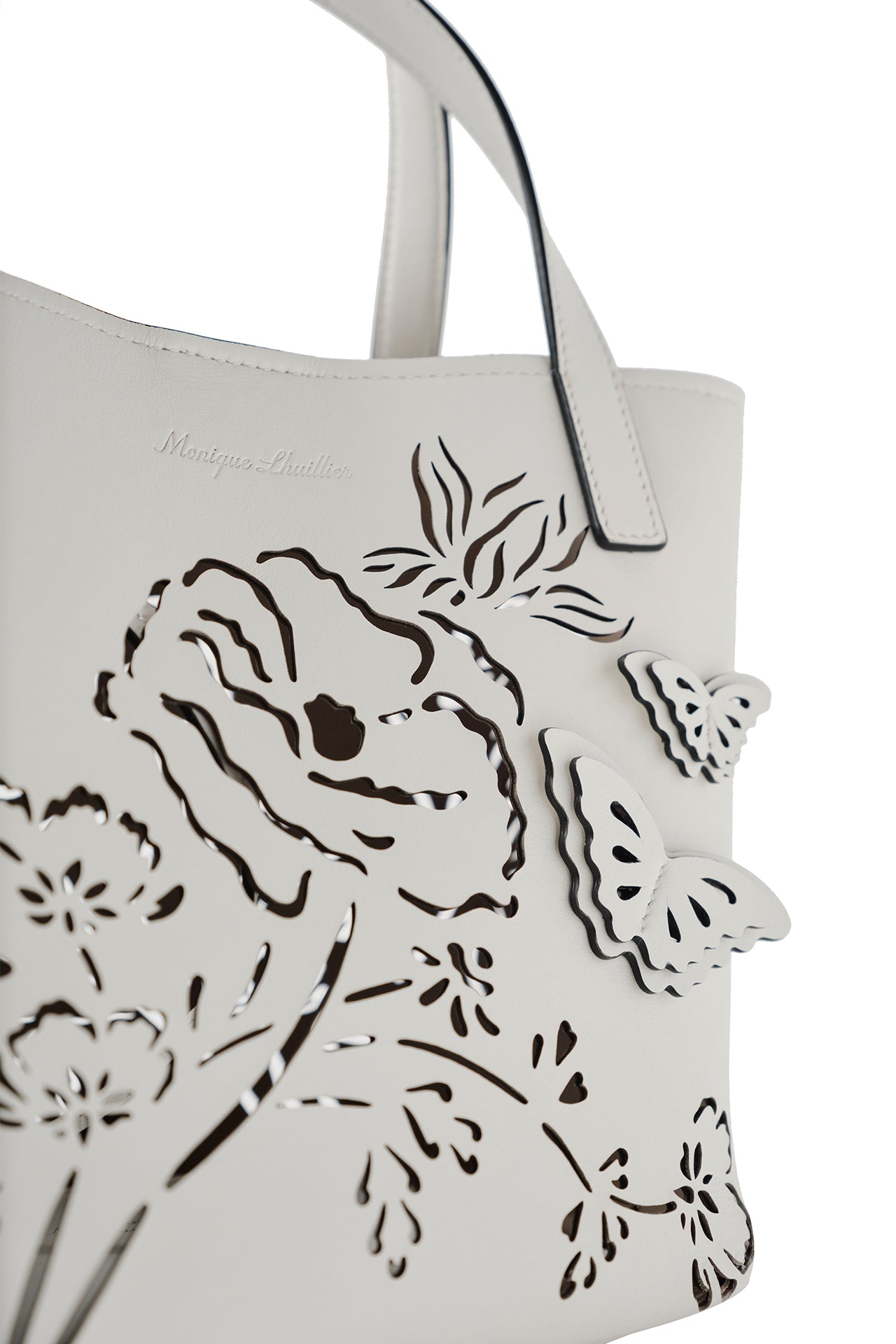 Leather top handle mini tote bag with laser cut florals, three-dimensional leather butterflies and small zip pouch in Ivory- front detail
