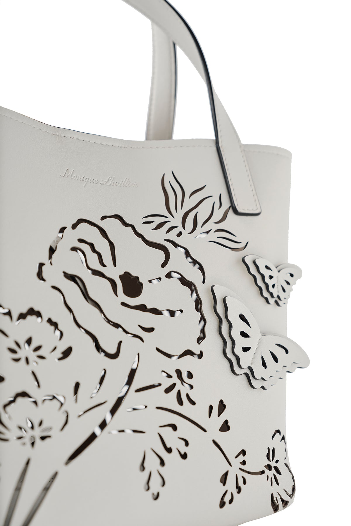 Leather top handle mini tote bag with laser cut florals, three-dimensional leather butterflies and small zip pouch in Ivory- front detail