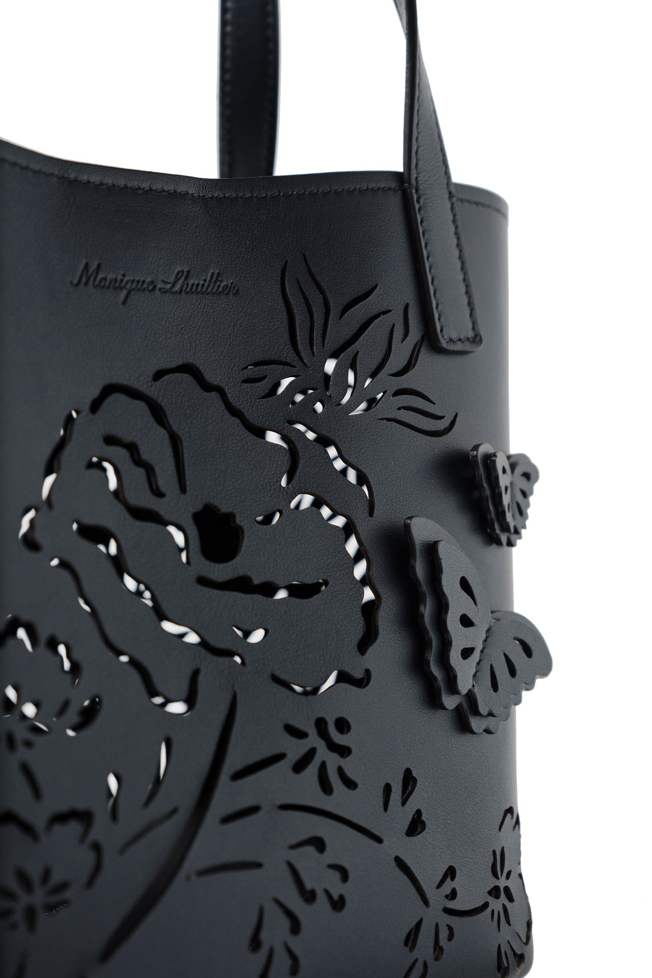 Leather top handle tote bag with laser cut florals, three-dimensional leather butterflies and small zip pouch in Navy- front detail