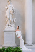 Woman wearing Monique Lhuillier Spring 2024 white off-the-shoulder long sleeve draped silk crepe Sussex column gown