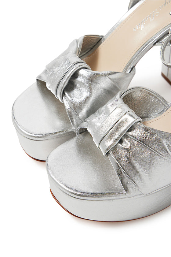 Monique Lhuillier silver leather Kris platform heel with knotted toe strap and silver hardware.