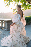 Woman wearing Monique Lhuillier Fall 2020 multi-colored floral printed Tuileries ballgown with off-the-shoulder billowed sleeves