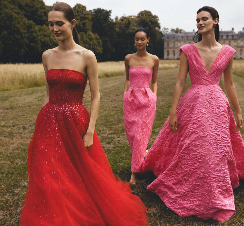 Monique Lhuillier strapless ballgown in cherry red embroidered tulle - models in red and fuchsia dresses.