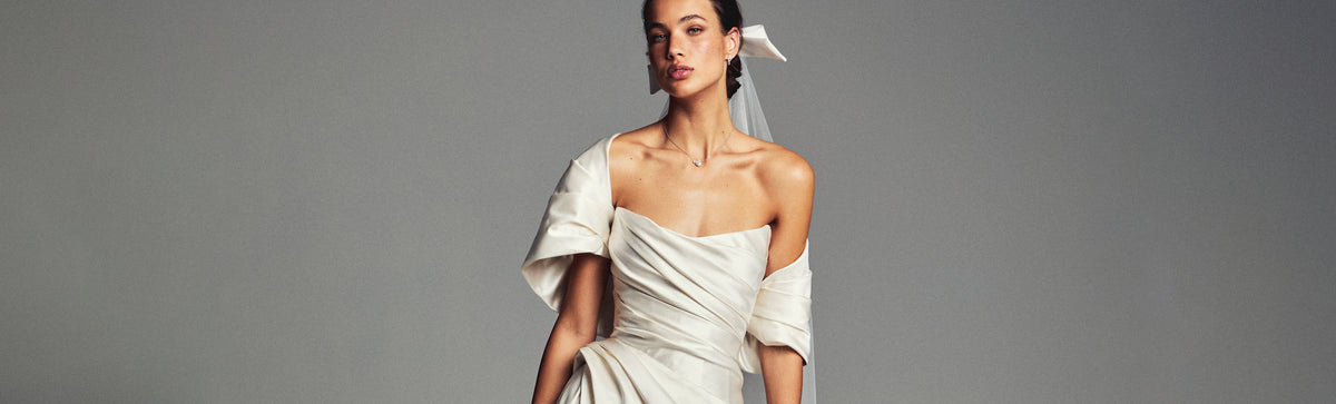 Monique Lhuillier Spring 2027 Bridal strapless draped A-line Campbell gown in ivory silk duchesse satin with asymmetrical draped shrug.