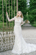 Woman wearing Monique Lhuillier Spring 2022 fitted white embroidered Mae scoop neck gown with matching long sleeve embroidered jacket