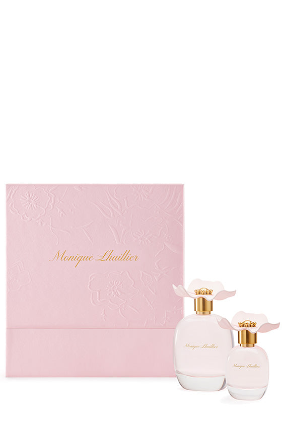 A gift set of Monique Lhuillier fragrance, including a 100 ml bottle and a 30 ml bottle of eau de parfum, presented in a pink box with floral patterns.