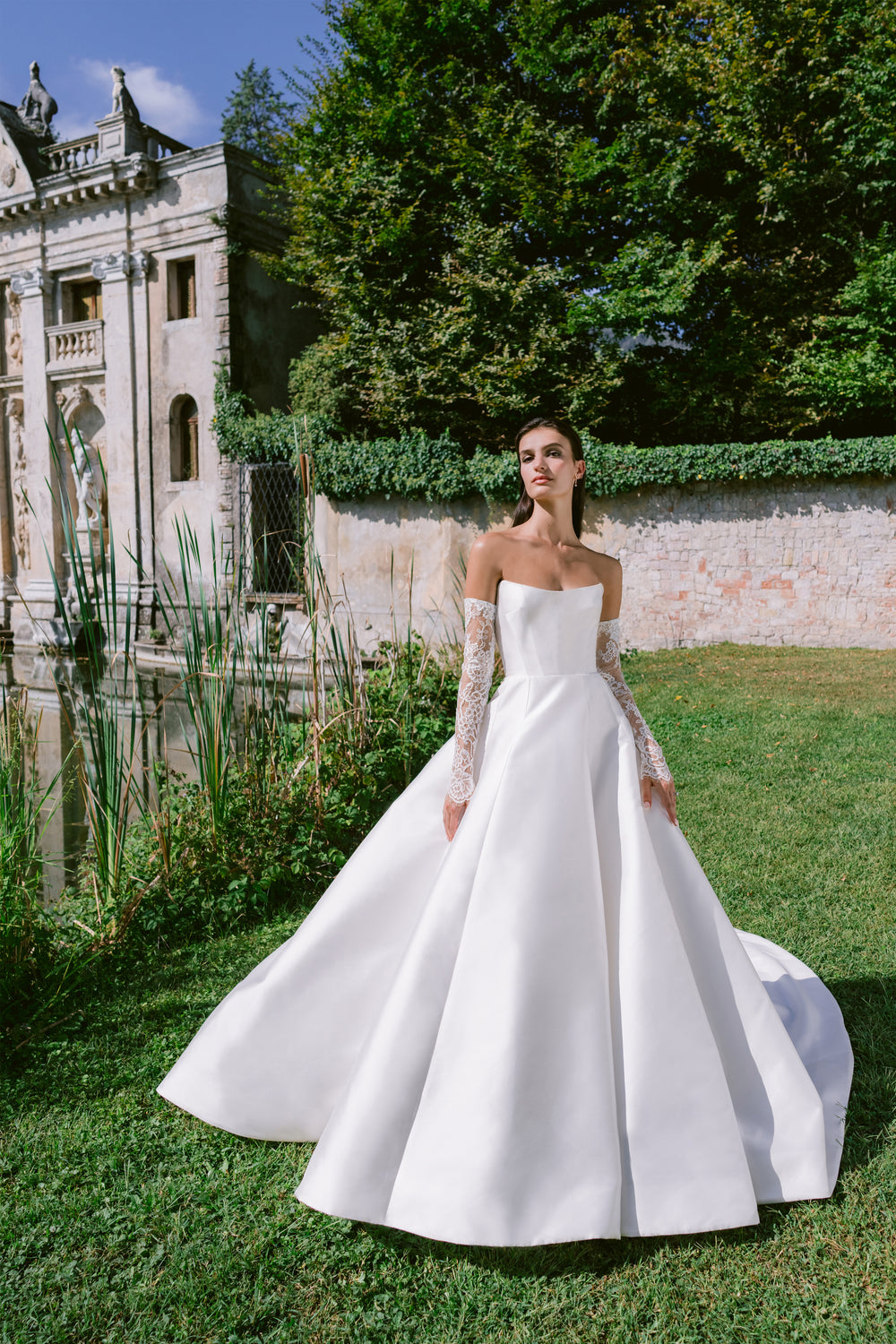 Model wearing silk white lace Sloane sleeves with a strapless bridal gown.