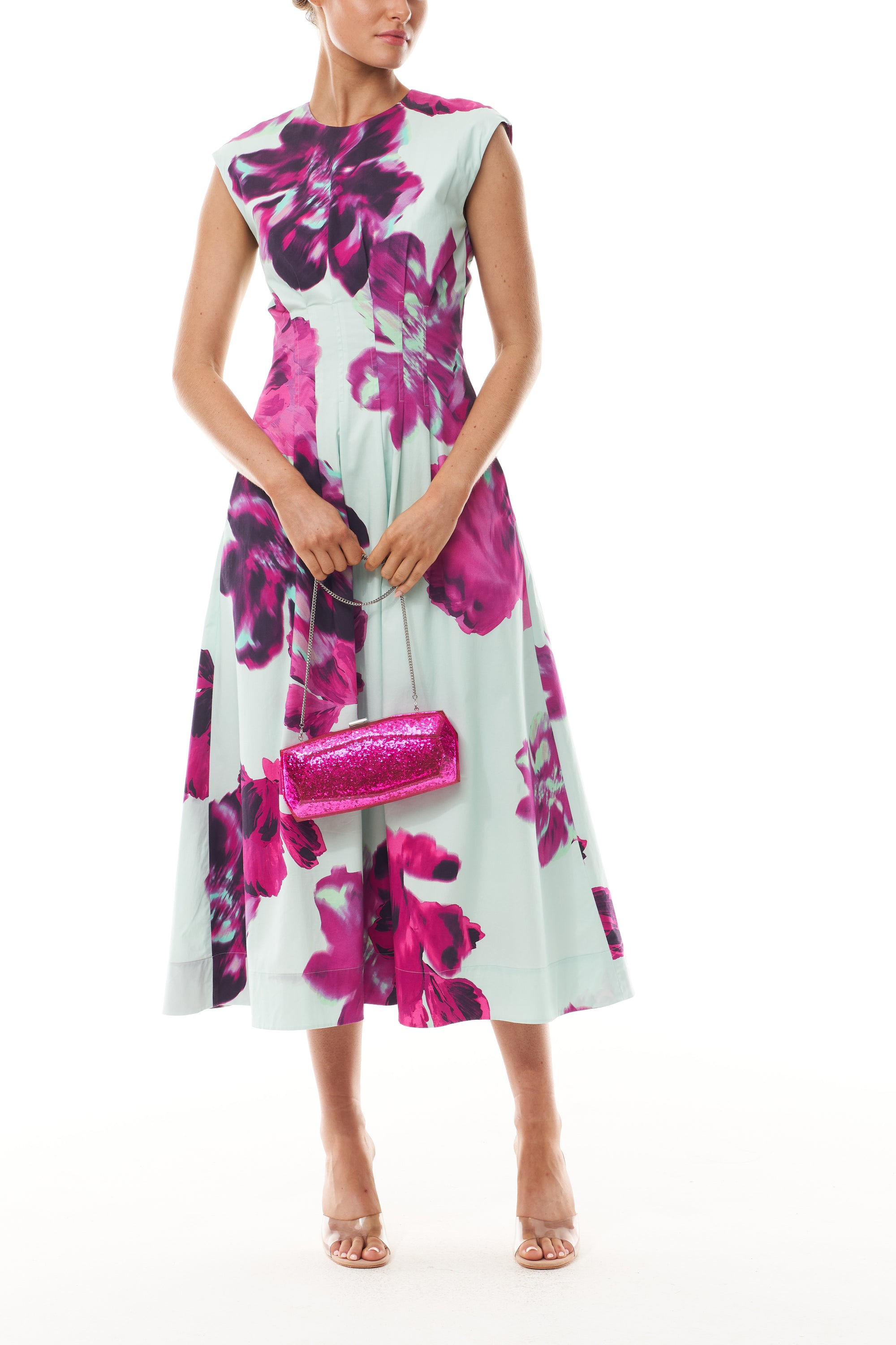 Monique Lhuillier Fall 2025 Lagoon Multi Electric Floral Printed Poplin sleeveless pleated day dress- front with Fuchsia Viv Minaudiere.