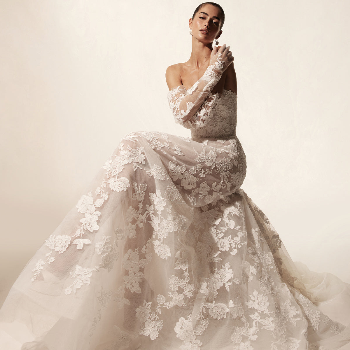 Model wearing Monique Lhuillier Spring 2026 Bridal white Vida threadwork lace strapless straight neckline corset bodice with soft ball gown skirt and matching Opera-length embroidered Vida gloves