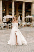 Woman wearing Monique Lhuillier Spring 2024 Bliss white strapless mikado BL24101 ballgown and detachable off-the-shoulder long sleeves