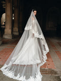 Mikado trumpet gown with draped bodice, lace sleeves and lace hem border. Paired with the Cathedral length, two tier lace trimmed veil.