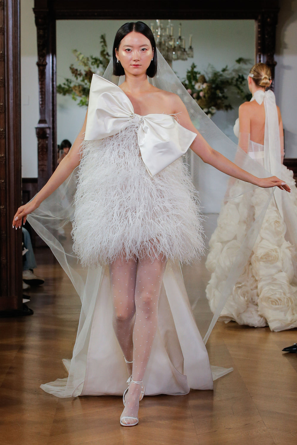 Monique Lhuillier Fall 2026 Bridal silk white duchess satin and feather Duffy cocktail gown with bow detail and streamers - runway.
