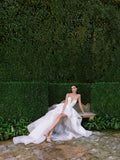 Woman wearing Monique Lhuillier Fall 2024 white lace strapless Harlow cocktail gown with lace Madame Butterfly overskirt