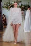 Monique Lhuillier Fall 2026 Bridal silk white/pearl scoop neck lace Rhiannon mini dress with feather floor length cape- runway.