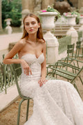 Woman wearing Monique Lhuillier Fall 2023 Bliss white lace strapless sweetheart fitted BL23202 gown with long train