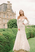 Woman wearing Monique Lhuillier Spring 2024 Bliss white embroidered lace BL24013 trumpet gown with detachable off-the-shoulder lace sleeves