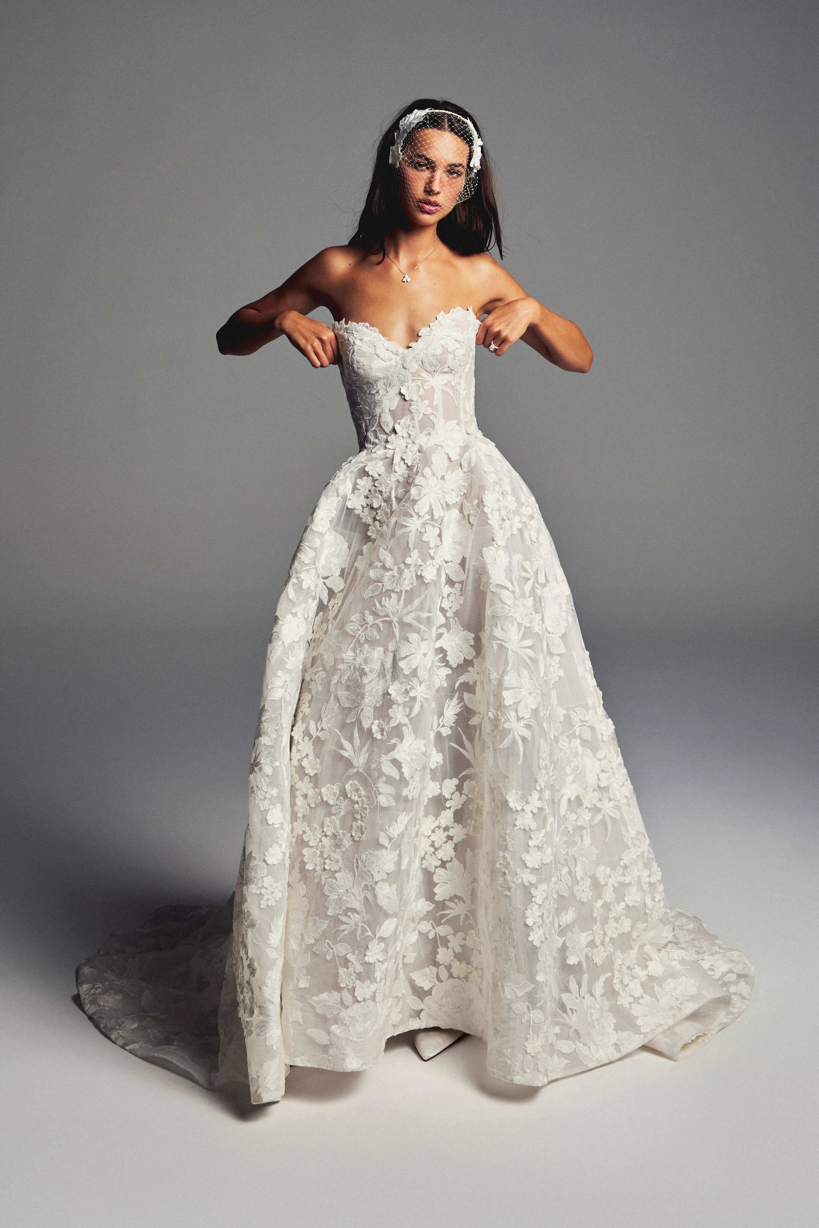 Monique Lhuillier Spring 2027 Bridal Strapless sweetheart June ball gown in silk white three-dimensional embroidered lace.