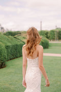Woman wearing Monique Lhuillier Spring 2024 Bliss white embroidered lace BL24013 trumpet gown