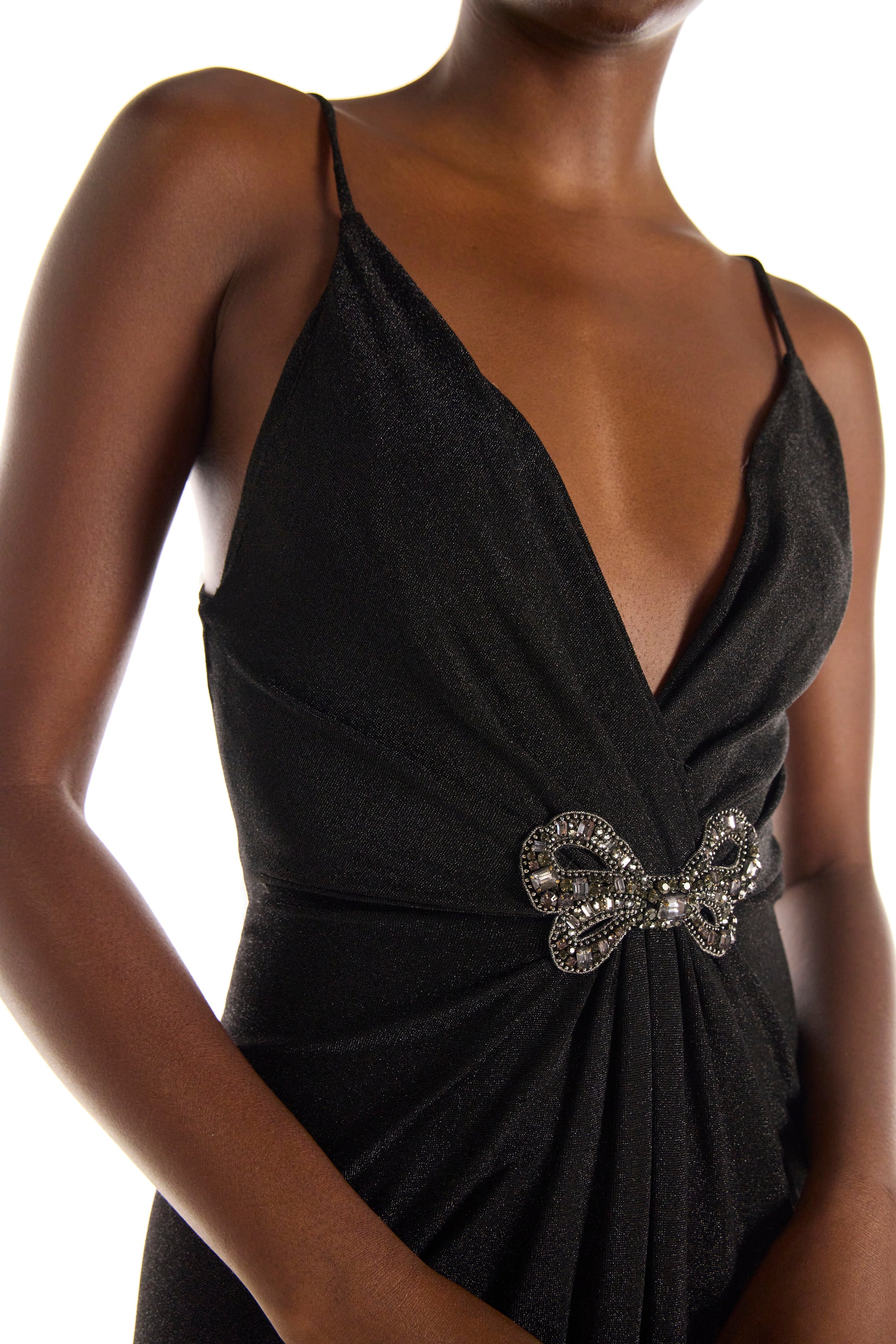 Monique Lhuillier black glitter knit gown with deep v neck, spaghetti straps and embroidered bow detail at bodice.