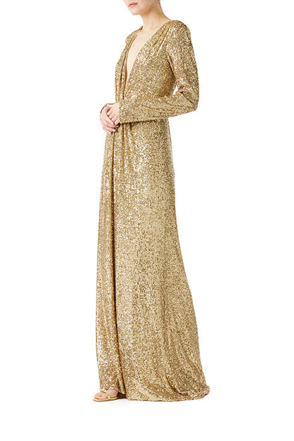 Monique Lhuillier long sleeve gown with deep v-neck and knot detail at waist in gold mini stretch sequin fabric.