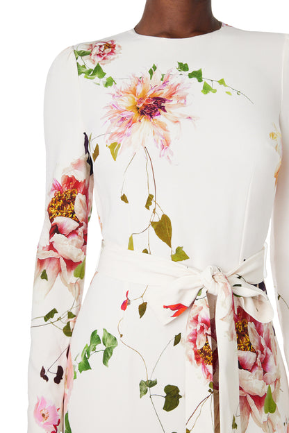 Monique Lhuillier jewel neck, tea-length gown with long sleeves and self-tie sash in silk white floral fabric.