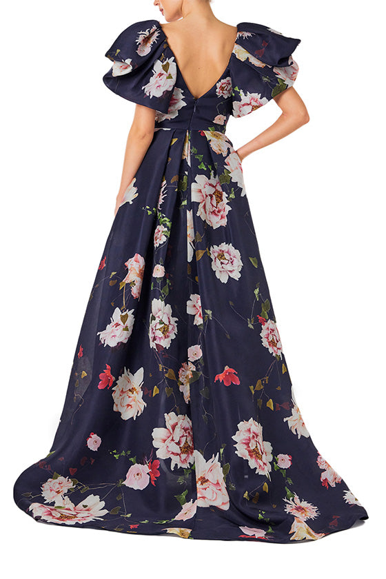 Monique Lhuillier navy floral gazar gown with deep v neckline, ruffle flutter sleeves and pockets.  
