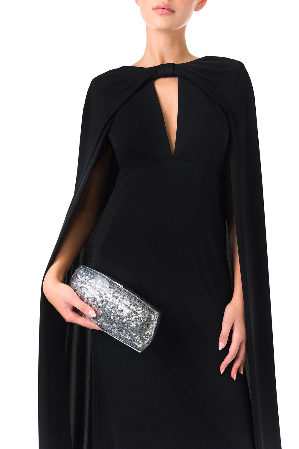Monique Lhuillier Spring 2024 black crepe-back satin gown with attached cape and keyhole bodice - front with Viv handbag.