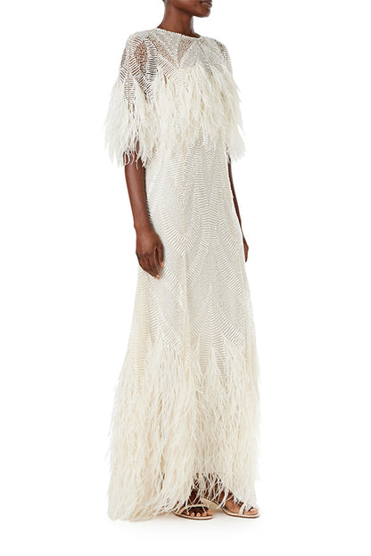 Monique Lhuillier Spring 2024 embroidered capelet gown with feathered trim.