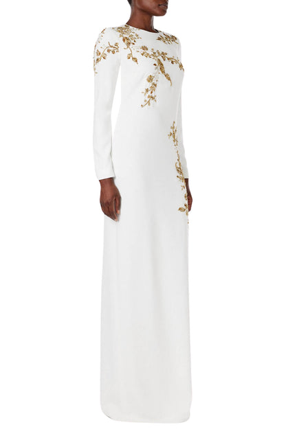 Monique Lhuillier silk white jewel neck, long sleeve column gown with gold embroidery.