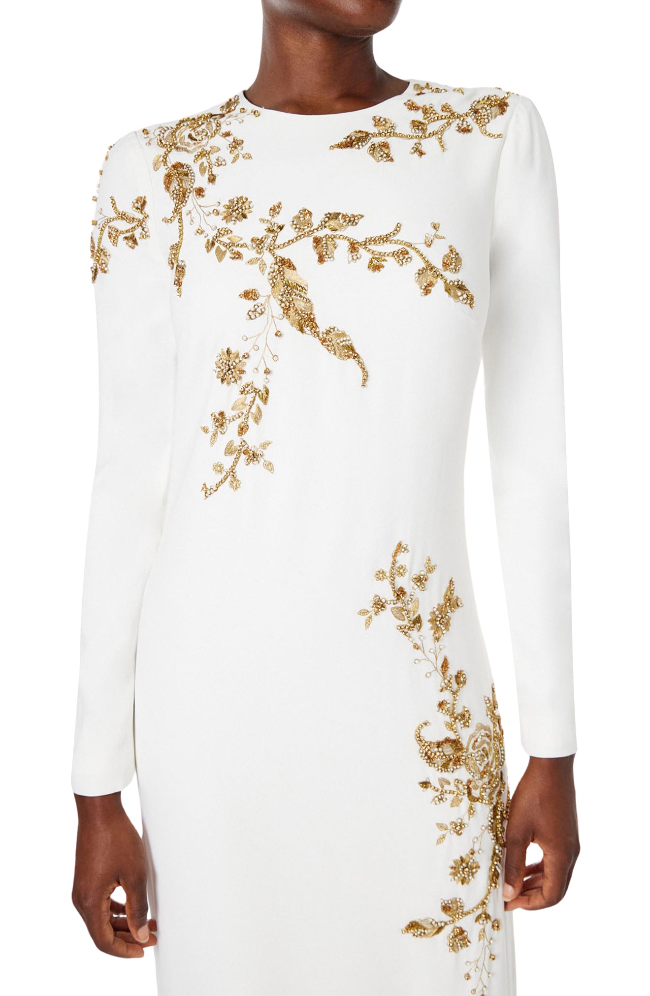 Monique Lhuillier silk white jewel neck, long sleeve column gown with gold embroidery.