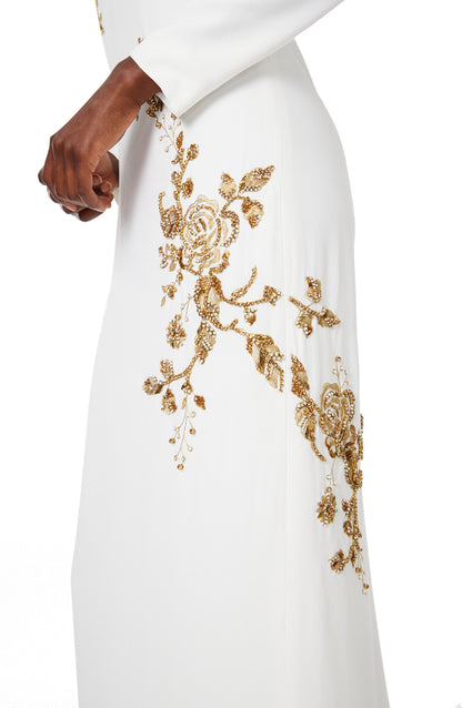 Monique Lhuillier silk white jewel neck, long sleeve column gown with gold embroidery.